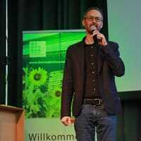 Klimabündnis-Geschäftsführer Norbert Rainer auf der Bühne der WeFair Linz 2021