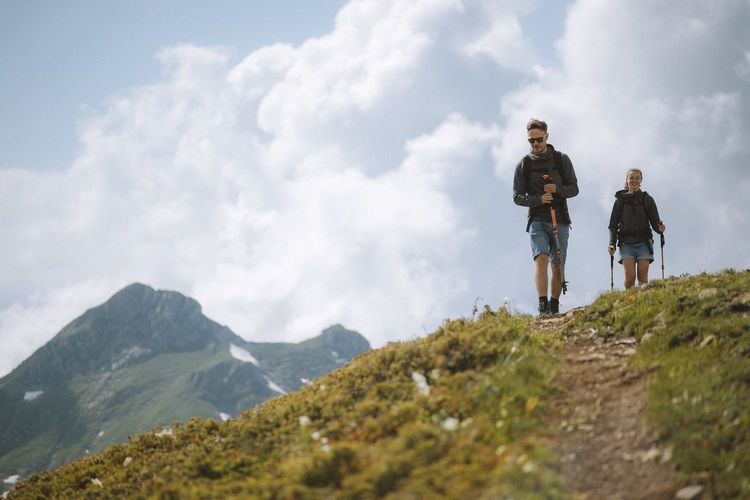 Zwei Menschen wandern auf einem Bergweg, Foto: Pexels / Yaroslav Shuraev